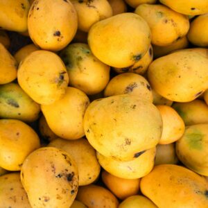 A close-up of ripe Indian mangoes in vibrant yellow hues, perfect for summer fruit themes.